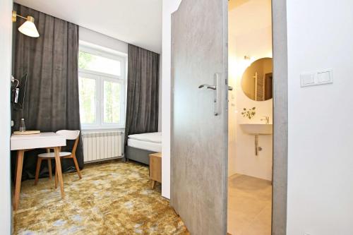 a room with a bathroom with a table and a sink at Willa Portus in Słupsk