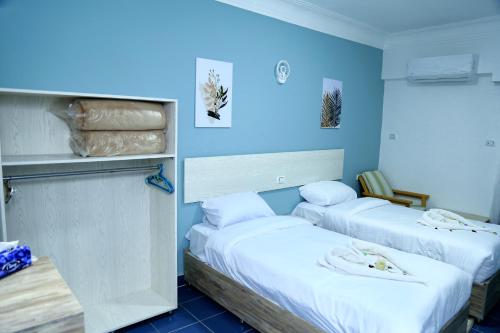 two beds in a room with blue walls at Lamera Hotel in Hurghada