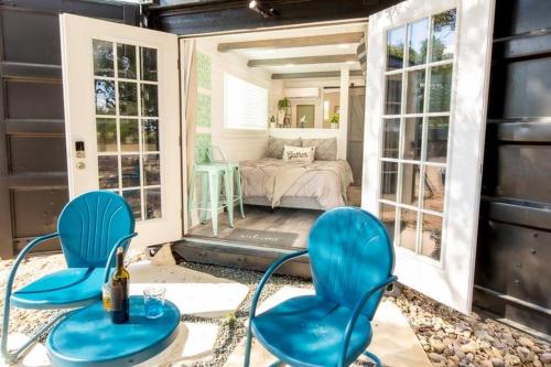 a room with two blue chairs and a bedroom at The Container Retreat @ 290 Wine Trail #10 Welcome friends! in Hye