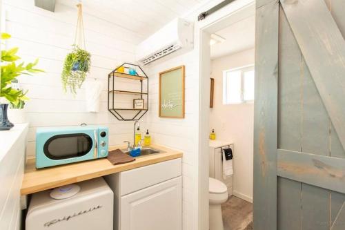 a bathroom with a sink and a microwave on a counter at The Container Retreat @ 290 Wine Trail #10 Welcome friends! in Hye