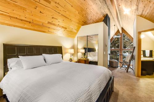 Snoqualmie Summit Chalet في Snoqualmie Pass: غرفة نوم بسرير كبير وسقف خشبي