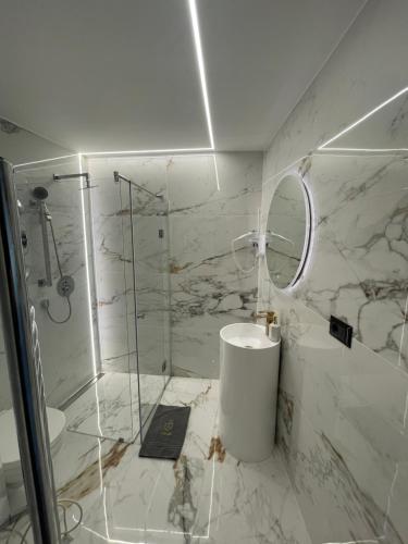 a white bathroom with a shower and a sink at TOP Luxury Suites in Budapest
