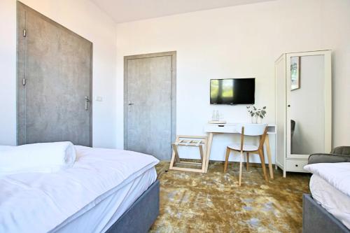 a hotel room with two beds and a desk at Willa Portus in Słupsk