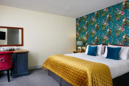a bedroom with a large bed with a large painting on the wall at The Christopher Hotel, Eton in Windsor