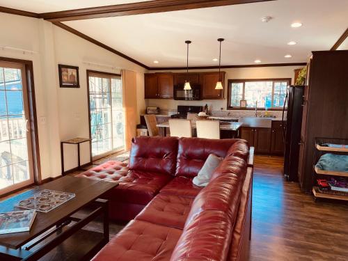 a living room with a leather couch and a kitchen at Swan Lake Resort in Galloway