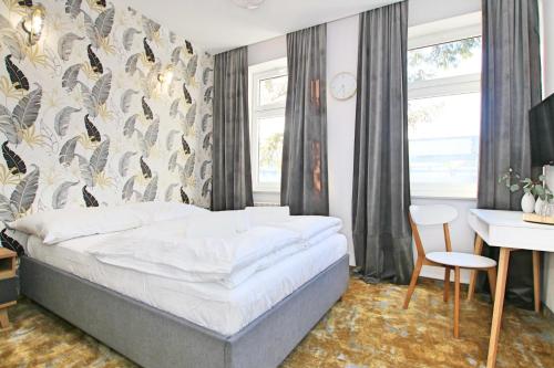 a bedroom with a bed and a table and a desk at Willa Portus in Słupsk