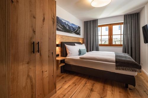 - une chambre avec un lit et une armoire en bois dans l'établissement Ferienwohnungen Manger, à Schönau am Königssee