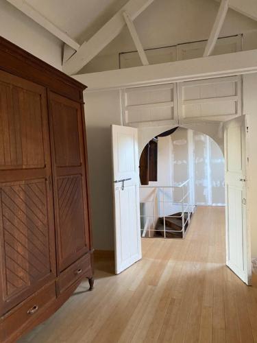 a room with a bed and a large wooden cabinet at B&B Le Moulin de Fernelmont in Forville
