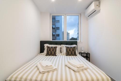 una camera da letto con un letto grande con asciugamani sopra di Stylish Apartment W/ River View by LovelyStay a Oeiras