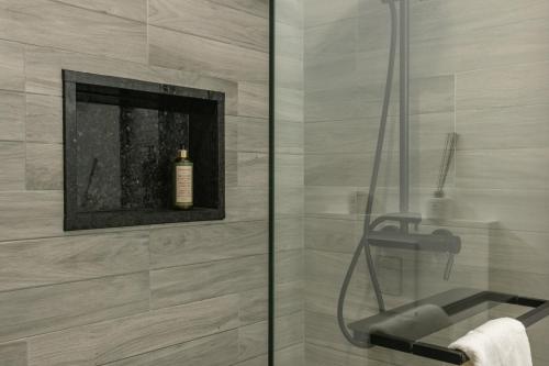 a bathroom with a shower with a bottle of soap at Stylish Apartment W/ River View by LovelyStay in Oeiras