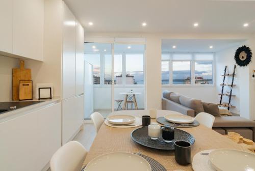 a kitchen and dining room with a table and chairs at Stylish Apartment W/ River View by LovelyStay in Oeiras