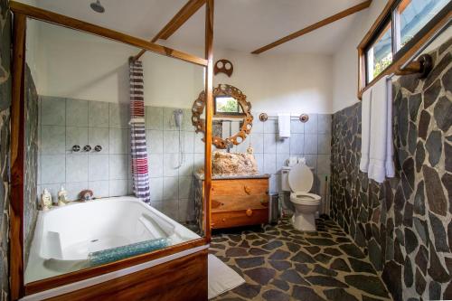 a bathroom with a tub and a toilet at Moon Wonders Vacation House in Monteverde Costa Rica