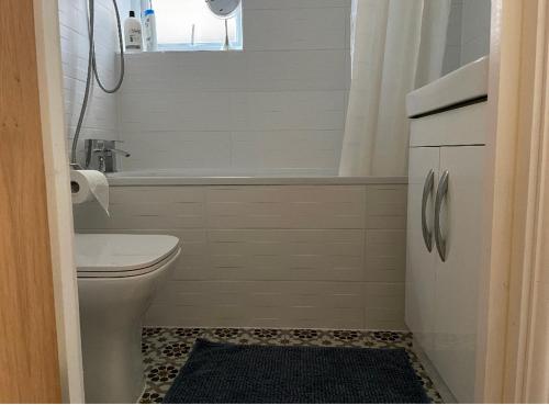 a bathroom with a toilet and a tub and a sink at Newly built modern flat at London Gants Hill Station near Ilford in Wanstead