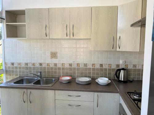 a kitchen with white cabinets and a sink at Appartements - Le Paradisier Ambatobe in Antananarivo