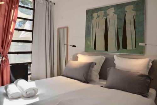 een slaapkamer met een bed met witte lakens en kussens bij LASUITE Domaine Bertuli, heated Pool, Aircon in Oppède