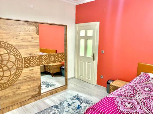 1 dormitorio con paredes rojas, espejo y cama en Luxury home in Beylikduzu, en Beylikduzu