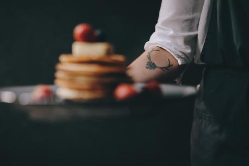 una persona con un tatuaje en el brazo junto a un pastel en Apartment Margarethenstein mit privat Sauna, en Kaprun