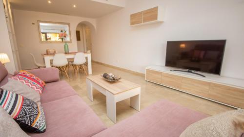 ein Wohnzimmer mit einem Sofa und einem Flachbild-TV in der Unterkunft Coto Real Duquesa Manilva in Manilva