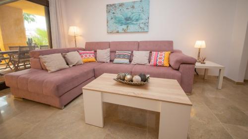 ein Wohnzimmer mit einem lila Sofa und einem Tisch in der Unterkunft Coto Real Duquesa Manilva in Manilva
