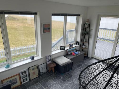 a living room with three windows and a chair at Wasterview, Central Mainland, Ideal base in Lerwick