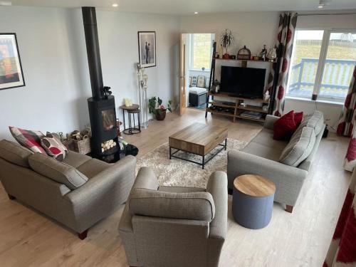 a living room with two couches and a fireplace at Wasterview, Central Mainland, Ideal base in Lerwick