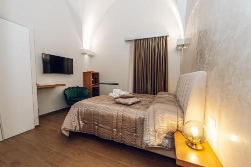 Habitación de hotel con cama y TV en Puro, en Mesagne