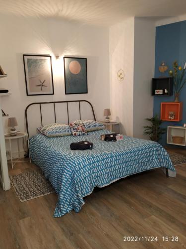 a bedroom with a bed with a blue blanket at studio vue imprenable sur marseille in Marseille