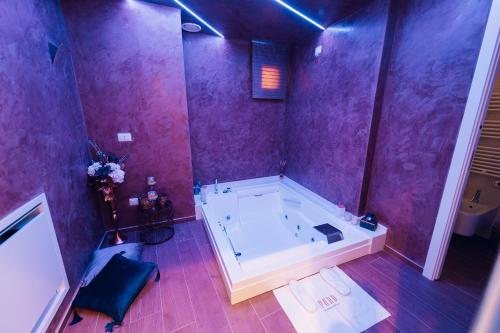 baño grande con bañera y paredes púrpuras. en Puro, en Mesagne