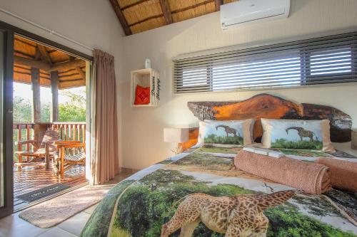 Un dormitorio con una cama con dos jirafas. en Call of the Fish Eagle Self-catering Holiday Home with solar, en Marloth Park