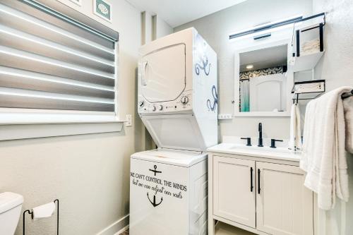 uma casa de banho branca com um lavatório e um espelho em Sea Cove em Galveston