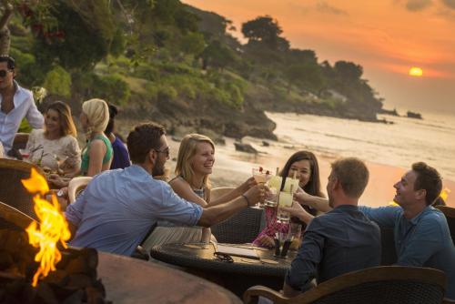 a group of people sitting around a table at the beach at Four Seasons Resort Bali at Jimbaran Bay in Jimbaran