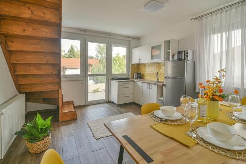 a kitchen with a table and chairs and a kitchen with a refrigerator at Happy Apartments in Balatonlelle