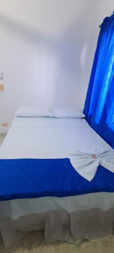 a blue and white bed with a blue blanket on it at HOTEL BRISAS DE SANTA FE in Santa Fe de Antioquia