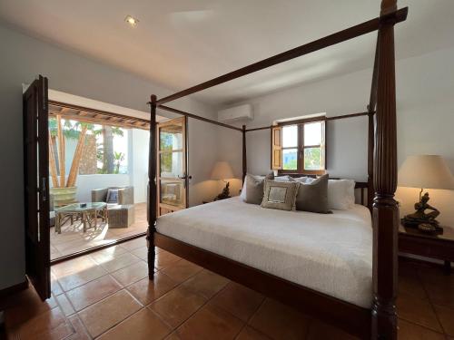 a bedroom with a canopy bed and a patio at VILLA SERENITY 3 Luxury boutique villa in Sant Jordi