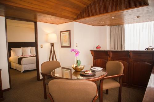 um quarto com uma mesa e cadeiras e uma cama em J&A Classic Hotel em Lima