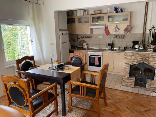 a kitchen with a table and chairs and a fireplace at Lexor Holiday Home in Tuzla