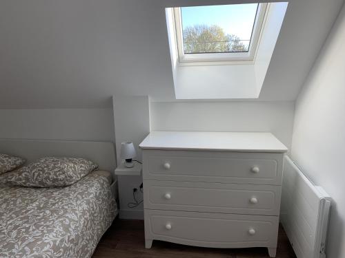 a bedroom with a white dresser and a window at Le Ch'ti Dodo 