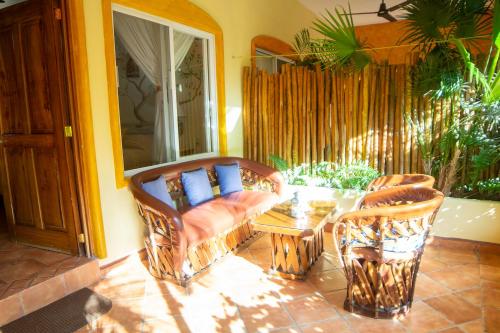 a patio with a couch and a table and chairs at Bungalows Jaqueline in Sayulita