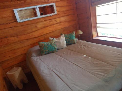 a bedroom with a bed in a log cabin at Cabaña Via Verde in Tandil