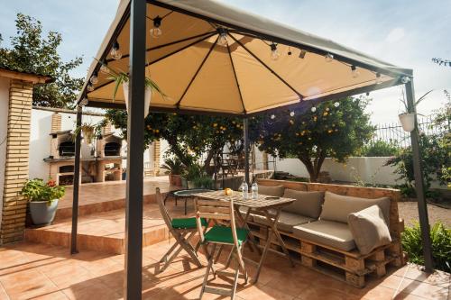 einen Regenschirm auf einer Terrasse mit einem Tisch und Stühlen in der Unterkunft Hostal Orange Vibes in Paterna