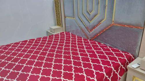 a bedroom with a pink and white comforter at Gulshan Guest House Gulberg Town in Karachi