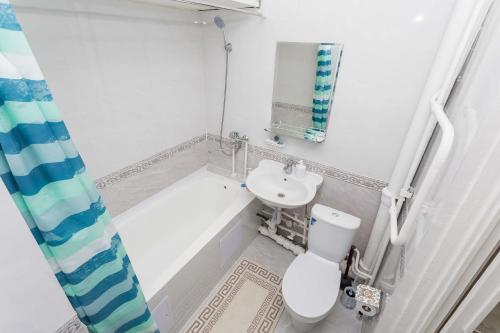 een witte badkamer met een toilet en een wastafel bij Апартаменты на Сатпаева in Alma-Ata