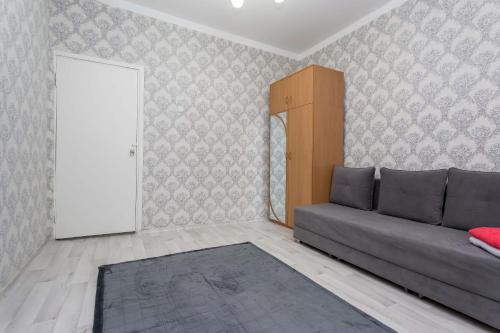 een woonkamer met een bank en een deur bij Апартаменты на Сатпаева in Alma-Ata