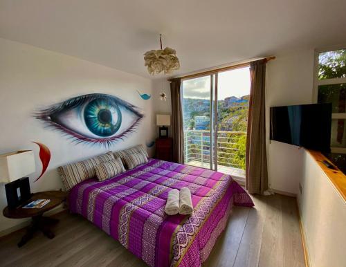 a bedroom with a large blue eye painted on the wall at MatiloftYungay in Valparaíso