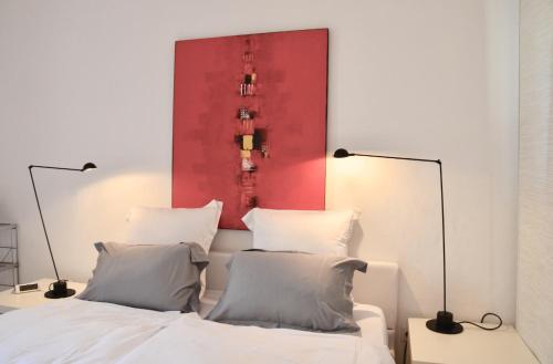 a bedroom with a red painting above a bed at Les Cerisiers maison bertuli climatisé, Piscine chauffée, lit King size, classé 5 étoiles in Oppède