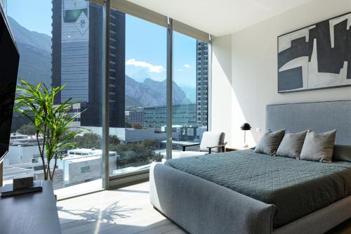 una camera con un letto e una grande finestra di Cerca de consulado EUA, nuevo, lujoso en Jardín Secreto 503 a Monterrey