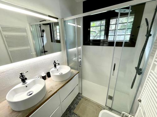 een badkamer met een wastafel en een glazen douche bij CASA PARAÍSO PISCINA TRANQUILIDAD in Sant Cebrià de Vallalta