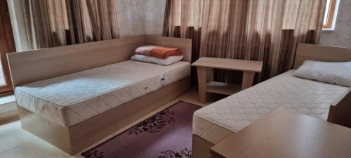 Kleines Zimmer mit 2 Betten und einem Tisch in der Unterkunft Snow magic Grand Monastery in Pamporowo