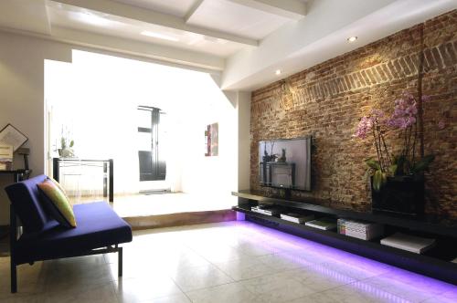 a living room with a tv and a brick wall at Amsterdam Boutique Apartments in Amsterdam
