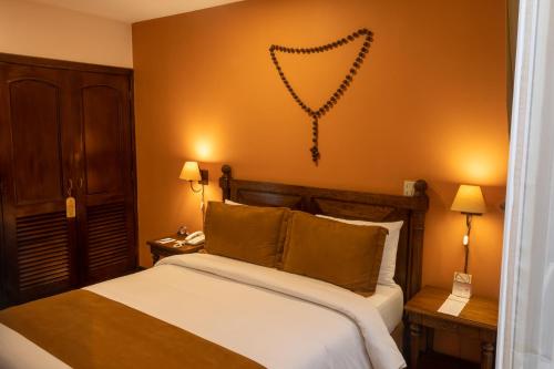 a bedroom with a large bed and a wall with aigraphy at Hotel Patio Andaluz in Quito